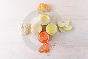 Baby vegetable puree of carrots, zucchini, cauliflower, potatoes in glass jars on white background, baby food concept, top view