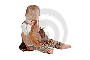 Baby in velvet dress plays peekaboo with toy