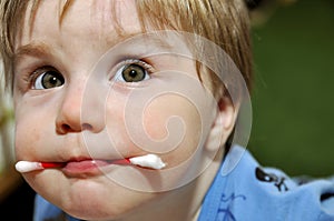 Baby with wadded stick in mouth photo