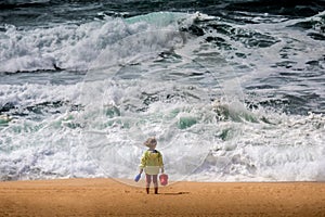 Baby watching stormy and windy ocean