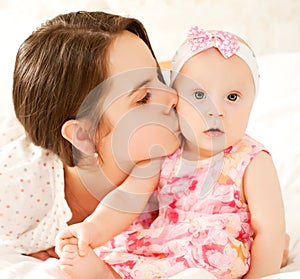 Baby wearing knitting hat and mother playing toget