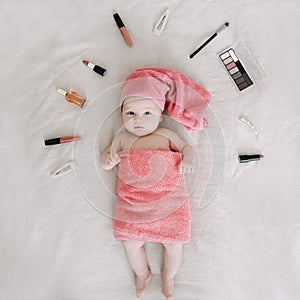 Baby wearing pink towel after bath. Childhood and baby care concept. Portrait of a cute funny girl 2-3 months old
