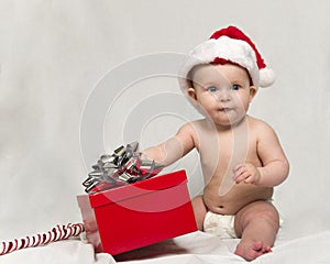 Baby Wearing Santa hat with Christmas Present