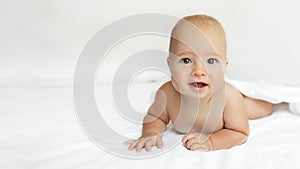 Baby on White background. Adorable two month old baby boy lying on the bad. Concept photo parenthood and motherhood