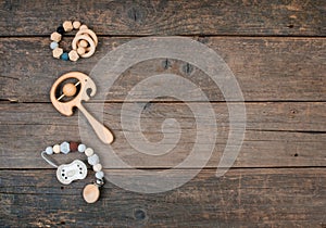 Baby wooden pacifier, beanbag and teether on rustic wooden background