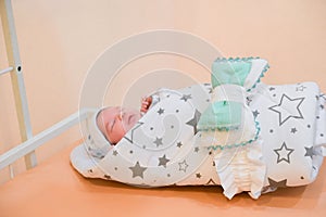 Baby wrapped in a blanket. Sleeping Cute Newborn Infant Wrapped in Baby Blanket in Acrylic Hospital Bassinet just after Birth