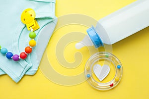 Baby yellow booties. Children's shoes and toys on yellow background. Newborn.