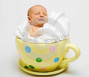 Baby in yellow spotted cup