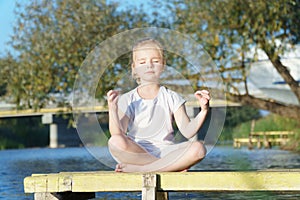 Baby yoga Lotus pose.. a child practicing yoga outdoors