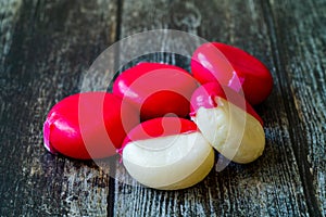 Babybel Cheese in Red Wex on Wooden Surface Ready to Eat