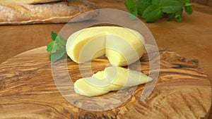 Babybel semi-hard cheese, baguette on a wooden board