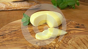 Babybel semi-hard cheese, baguette on a wooden board