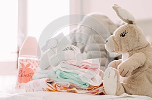 Babyshower gifts, shoes, puppets, clothes, feeding bottle, with modern chic style, standing on table indoors at home