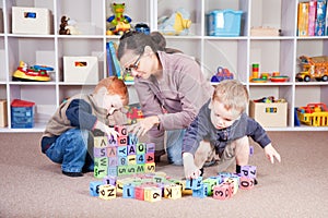 Babysitter playing kids block game with children