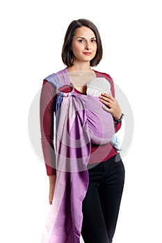 Babywearing attractive young mother with baby in woven wrap carrier. Free hands and active motherhood concept idea