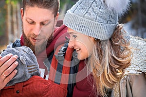 Babywearing winter walk of young parents with their children outdoor