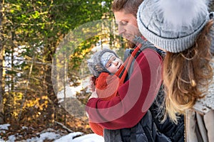 Babywearing winter walk of young parents with their children outdoor, copy space