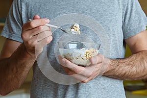 Bachelor man daily routine in a kitchen single lifestyle concept muesli with yoghurt close-up