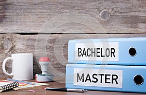 Bachelor and Master. Two binders on desk in the office. Business