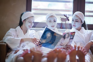 Bachelorette party in spa, girls with face mask reading magazine