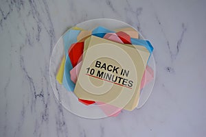 Back in 10 Minutes write on sticky notes isolated on Wooden Table