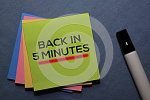 Back in 5 Minutes on sticky notes isolated on Office Desk