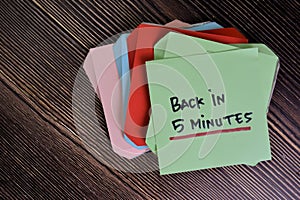 Back in 5 Minutes write on sticky notes isolated on Wooden Table