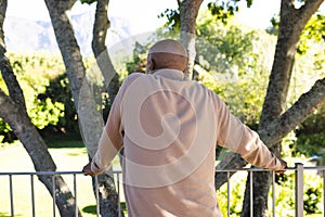 Back of african american senior man on sunny terrace