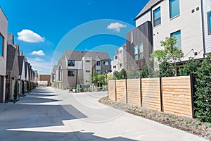 Back alley of brand new three story houses with wooden fence near downtown Dallas