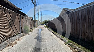 Back alleyway road behind stores and buildings wooden fence