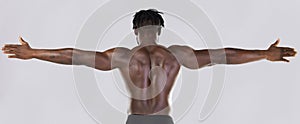 Back, arms and muscular with a model black man posing in studio on a gray background for fitness or exercise. Muscle