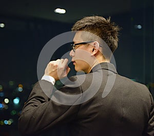 Back of Asian Business man thinking at night with bokeh