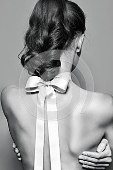 Back of beautiful gentle girl with silk bow on the neck