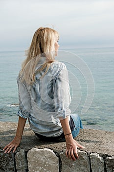 Back of blonde woman traveler enjoying the views on sea in summer. Montenegro