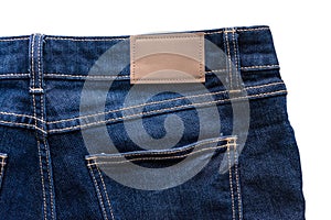 Back of blue jeans with leather jeans label sewed on blue jeans.