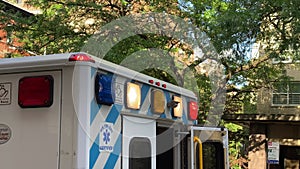 Back, blue and white Ambulance emergancy unit first responder with flashing lights at location