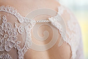 Back of bride in wedding dress with string of pearls