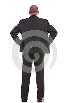 Back of a business man standing with hands on hips