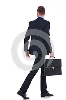 Back of a business man with suitcase walking away