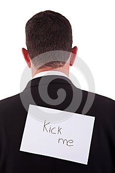 Back of businessman, with kick me written in paper