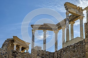 Back of the capitals, columns and cornices of the stage of the Roman theater in Merida, with the midday sun illuminating the