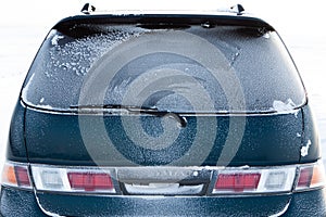 The back of the car, completely covered with frost after a winter blizzard