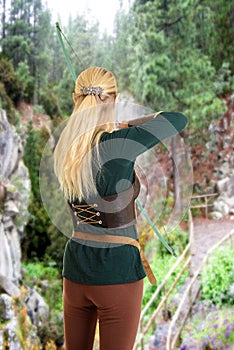 Back of female elf shooting a bow and arrow