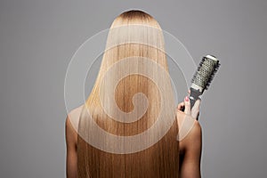 Back of girl with Healthy hair. Care and styling hair with a comb