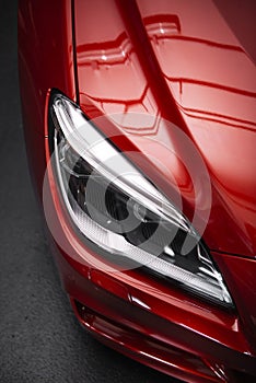 Back headlight of a modern luxury red car, auto detail, car care concept in the garage