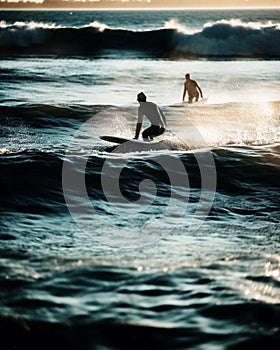 Back light view of a couple of surfers waiting for the wave