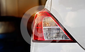 Back lights of white car after the rain on car parking