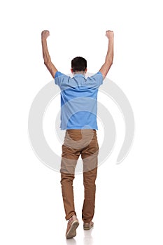 Back of a man walking with hands in the air