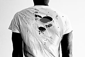 Back of a man wearing a torn white t-shirt