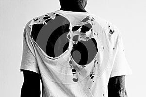 Back of a man wearing a torn white t-shirt
